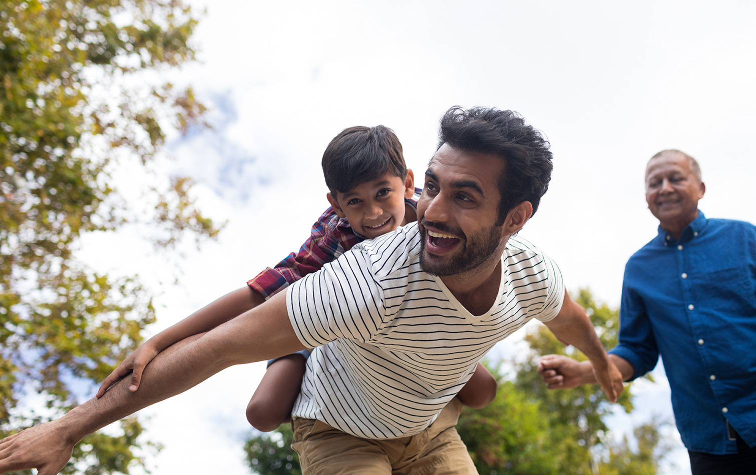 Father, Grandfather and son playing in a park